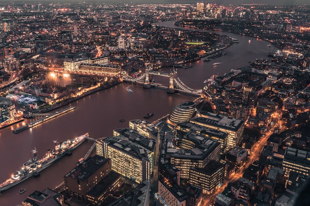 Der Fluss Thames und London bei Nacht aus der Luft fotografiert.
