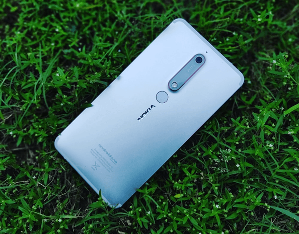 Ein Nokia-Handy liegt im Gras. Dabei ist die Rückseite mit dem Nokia Logo zu sehen.