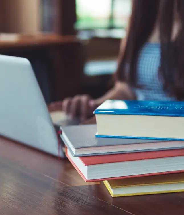 Bücherstapel neben einem Laptop